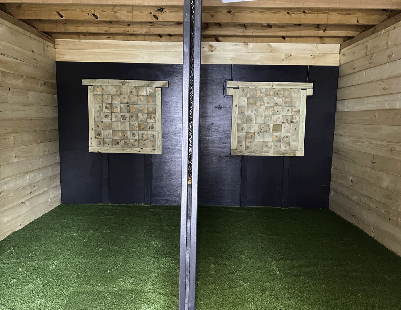 Two axe-throwing lanes with wooden targets on turf